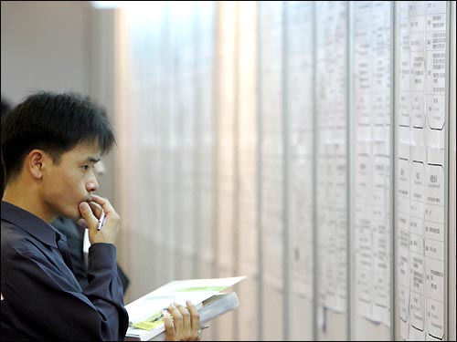 2005년 말 서울의 한 대학교에서 열린 채용박람회에서 한 취업준비생이 업체의 채용공고를 살펴보고 있다. (이 사진은 기사 내용과 특정한 관련이 없음)
